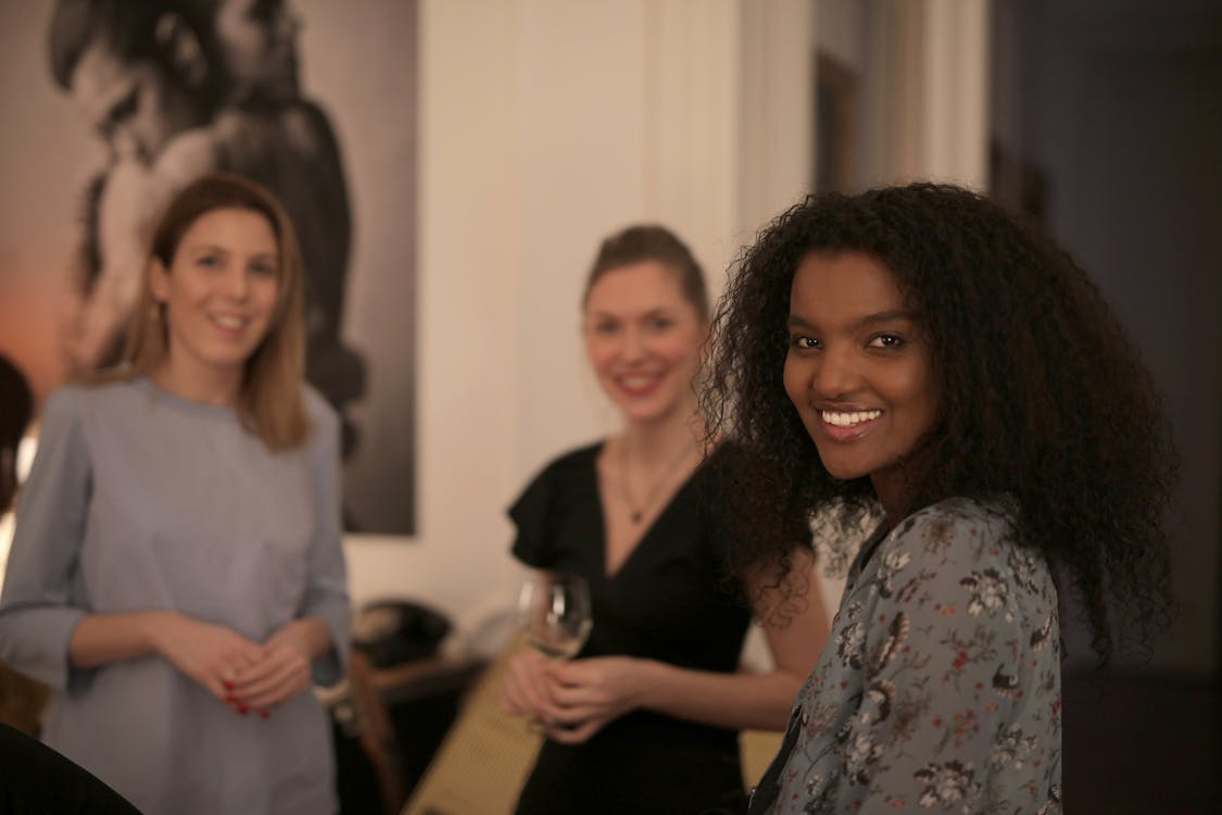 Three women smiling while looking in the camera