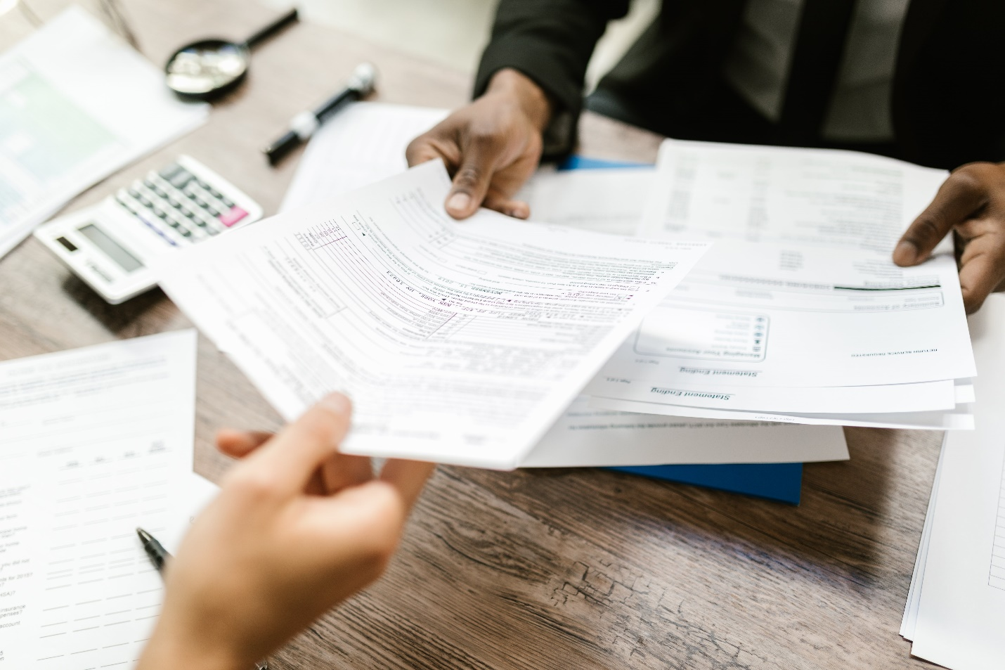 Business professional handing out documents in a corporate setting to another person