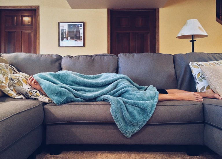 A person is feeling sick and resting at home in a cozy environment