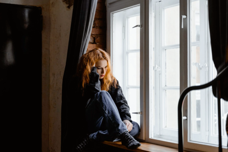 An image of a woman sitting near a window