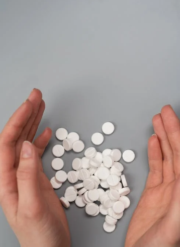 A person gathering white pills