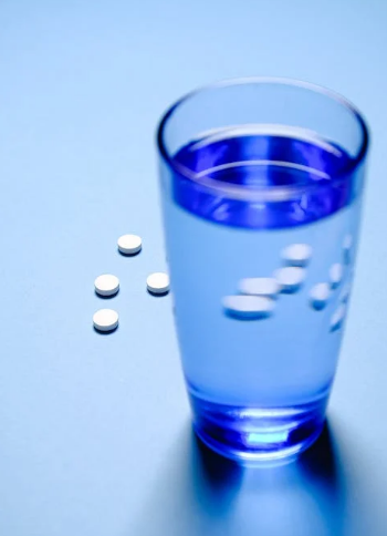 Pills placed next to a glass of water