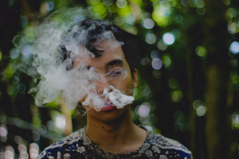 A young boy exhaling smoke