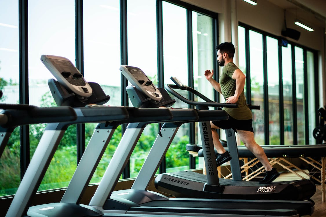 A man running on a treadmill in a gym