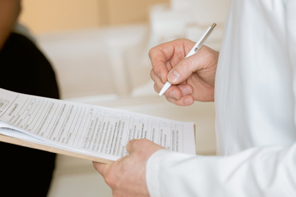 An image of a person holding a pen and paper