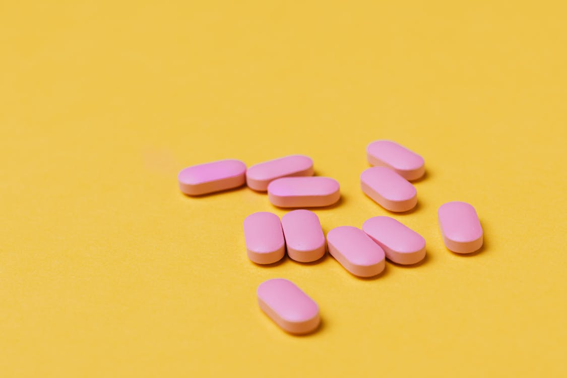Pink pills on a yellow surface