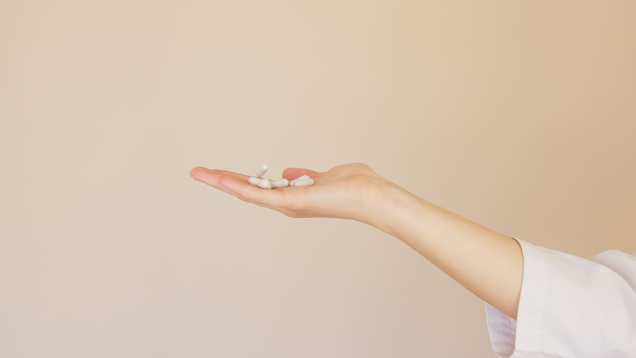 An image of pills on a person’s hand