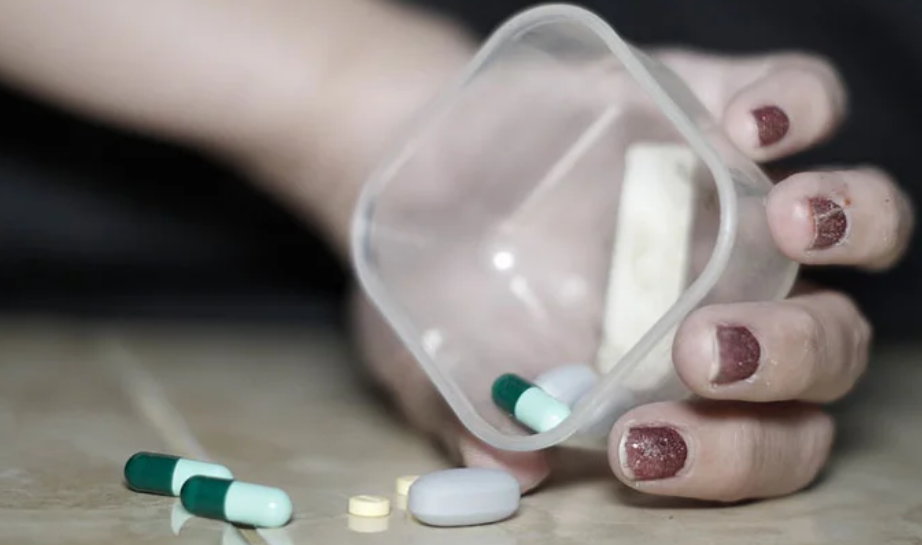 A person holding a box of pills