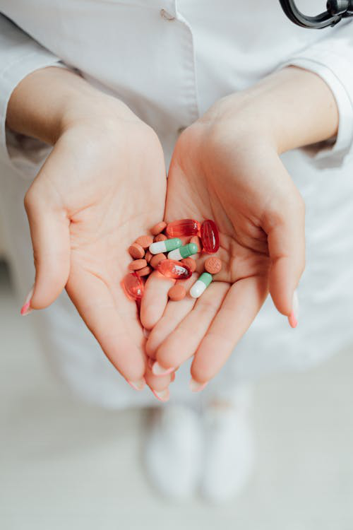 An image of a woman holding pills in her hand