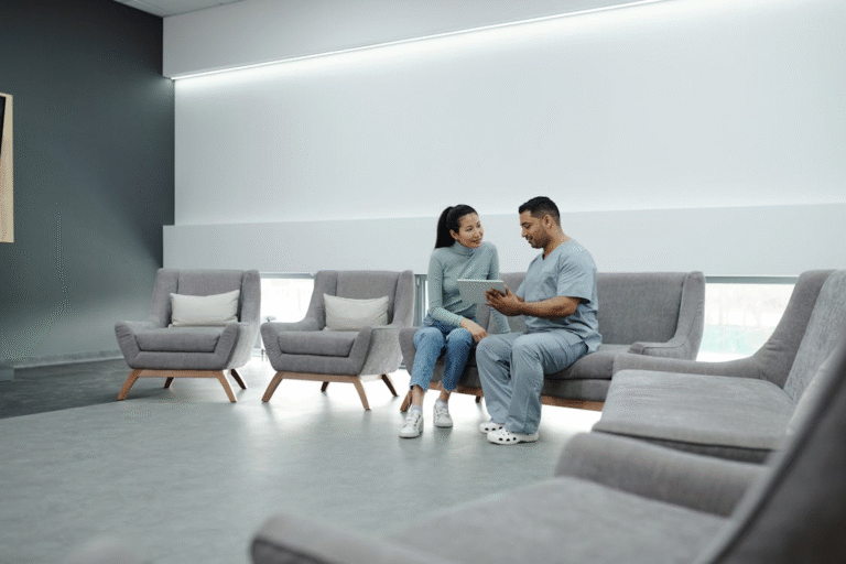 An image of a man talking to a woman while sitting on a gray couch