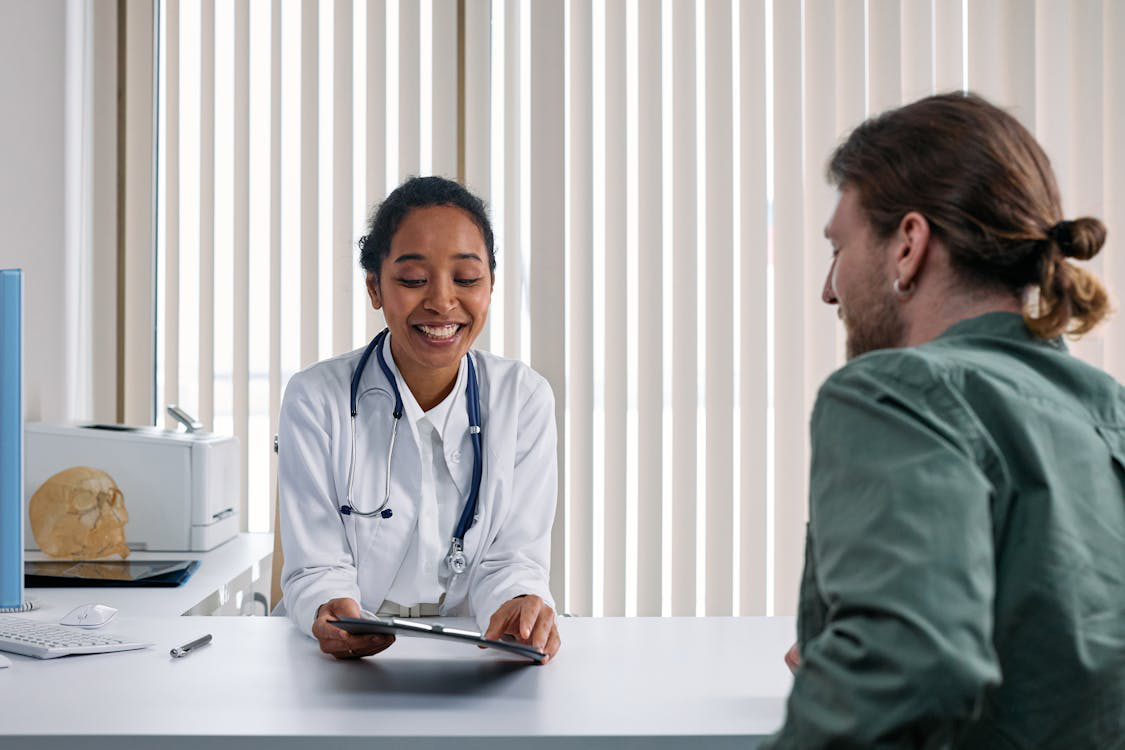 An image of a man talking to a woman over the desk
