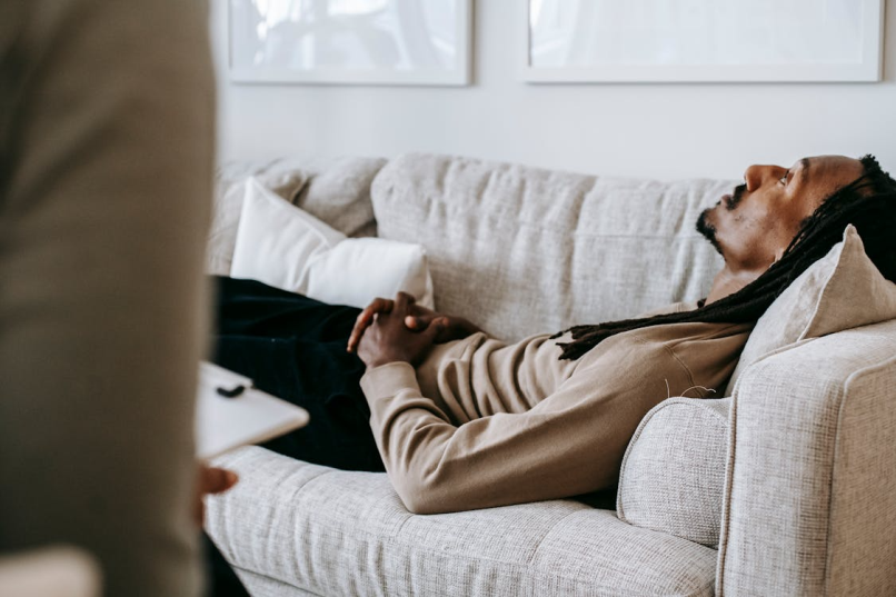 An image of a man talking to a therapist while resting on a couch 