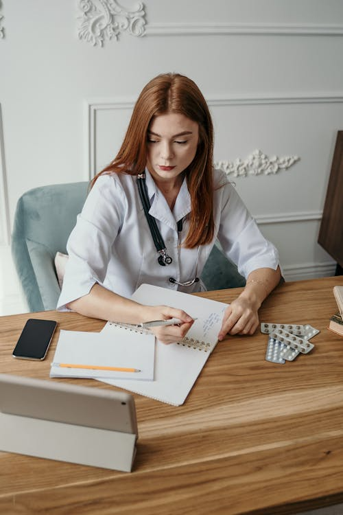 An image of a woman writing on a desk