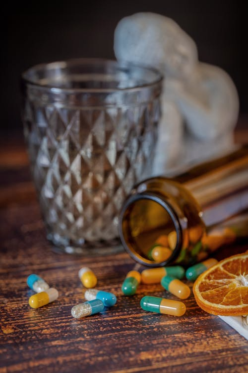 An image of green and white pills on a blue surface