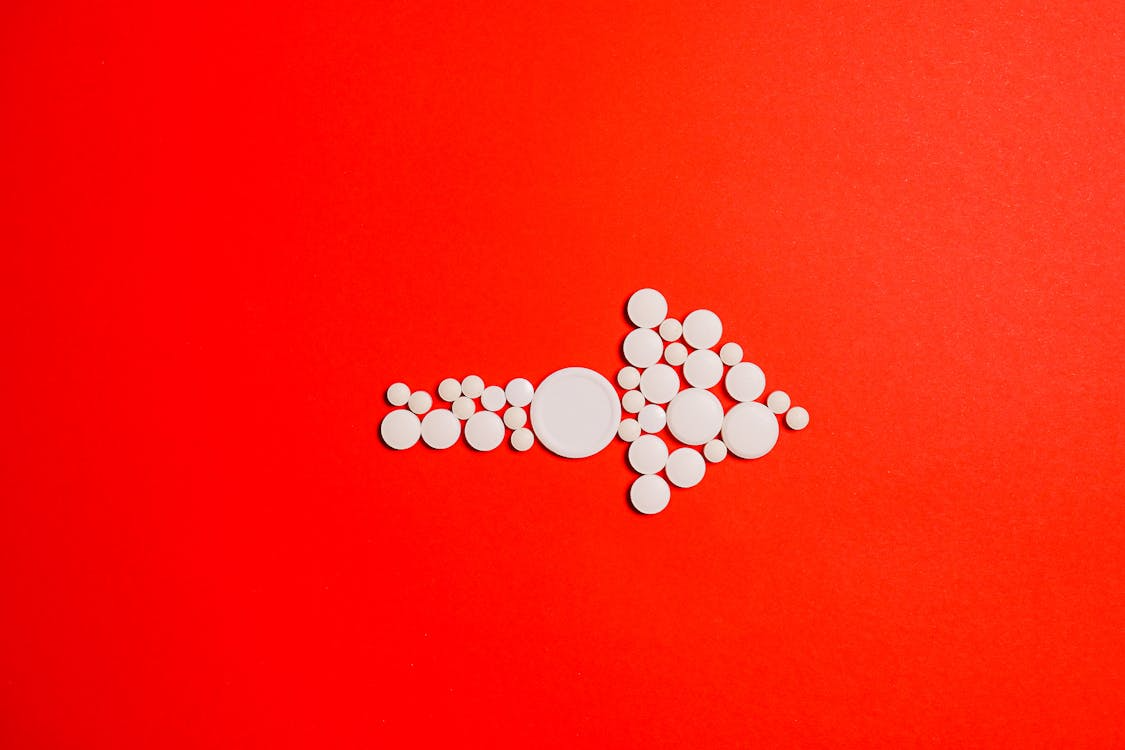 An image of white medicine on a red surface