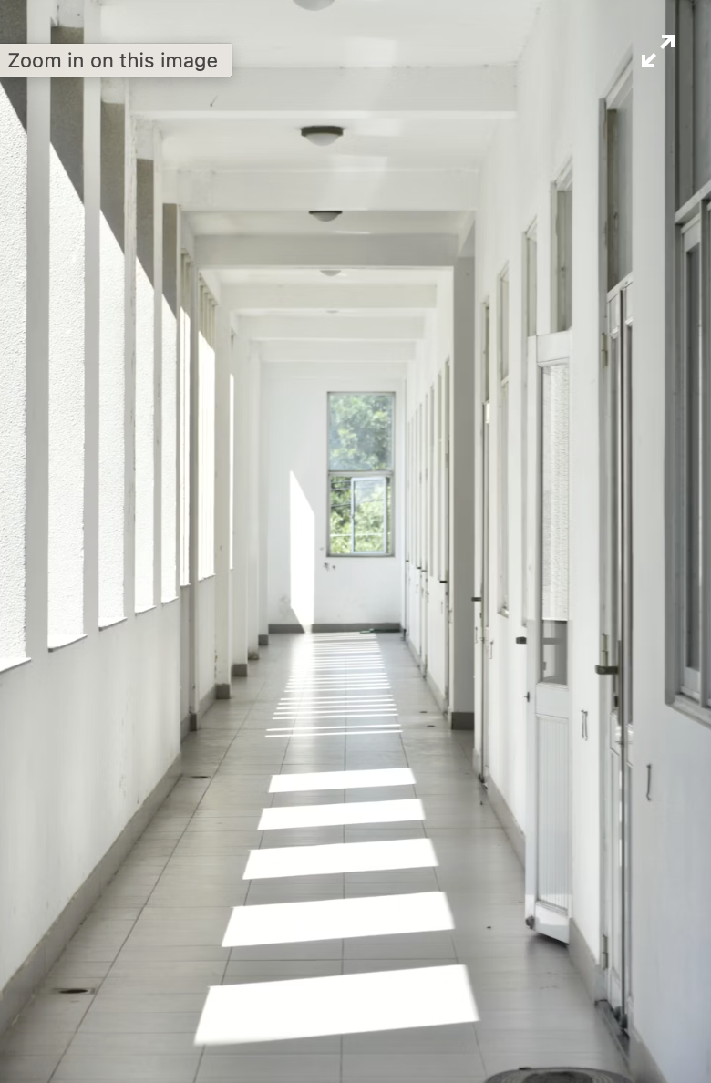This photo shows a clinic hallway with sunlight through windows.