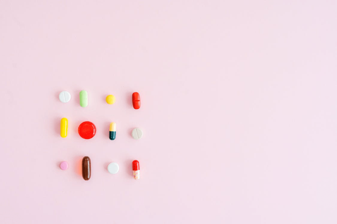 : An image of pills on a pink surface