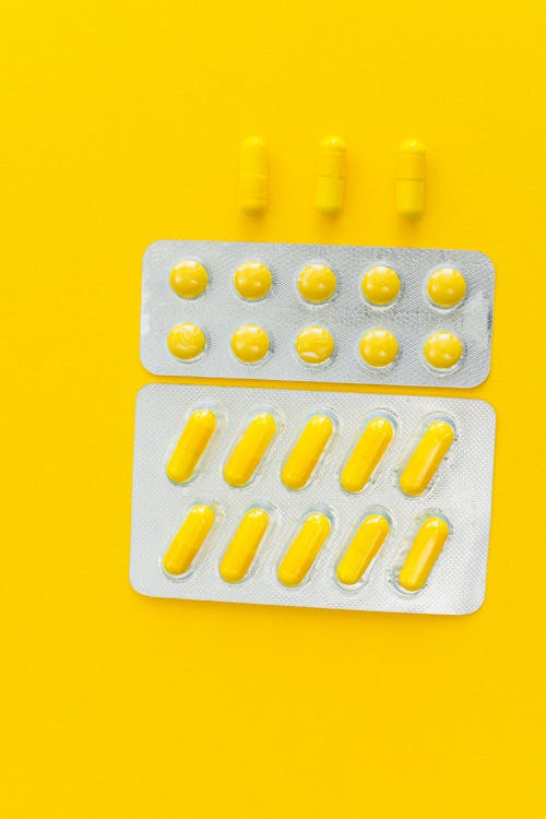 An image of pills on a yellow surface