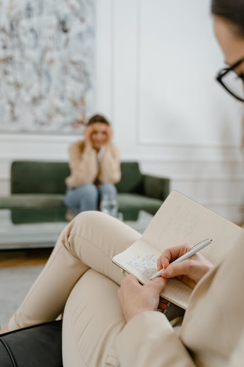 An image of an addiction therapist taking notes during a session