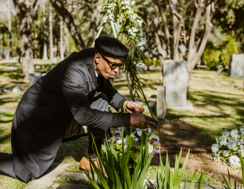 This image shows a man sitting near the flower.