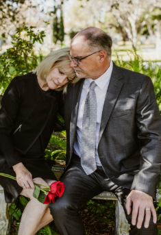 This image shows a couple sitting on a concrete bench.