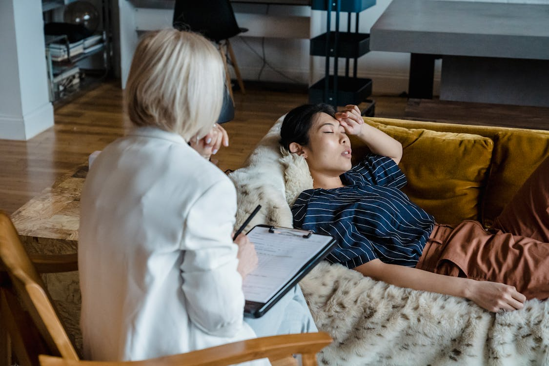 An image of a woman speaking to an addiction therapist while lying down on a sofa