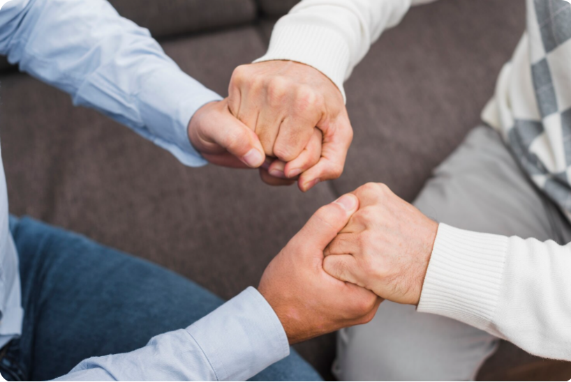 Two people holding hands in a supportive and caring gesture