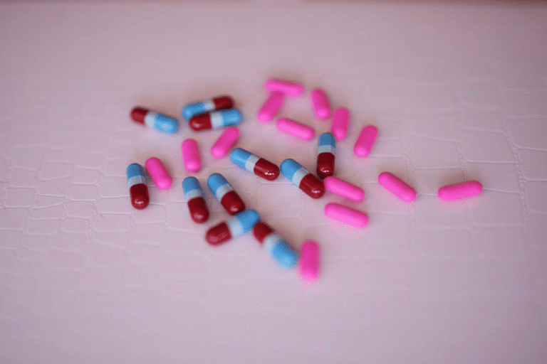 An image of pills on a pink surface