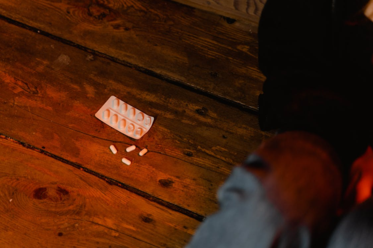 An image of pills on a wooden surface