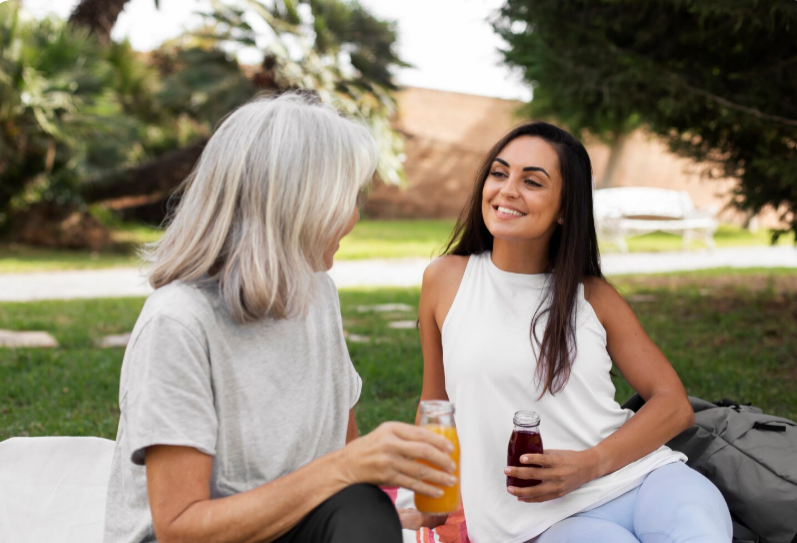 Friends practicing yoga together in a park and drinking juice as part of a healthy lifestyle