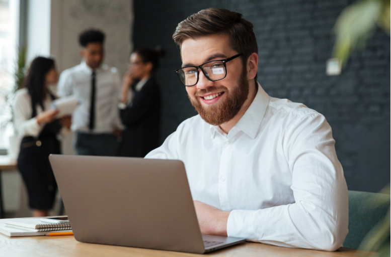 Man in recovery working on laptop in office environment representing return to work and daily functioning stability