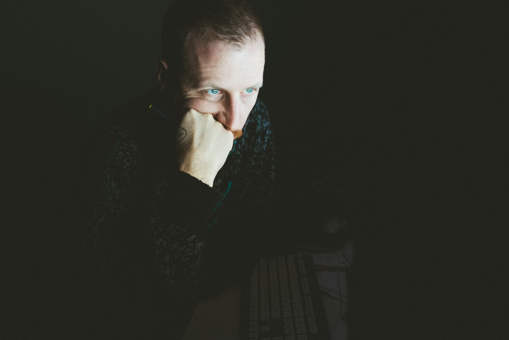 Man sitting alone in low light, reflecting during the early emotional phase of opioid recovery