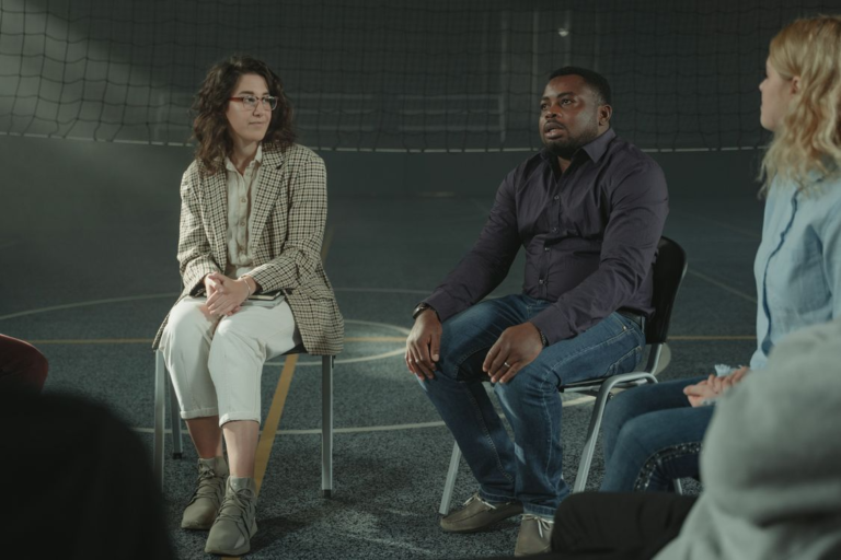 A diverse group of adults participating in a peer support group for recovery