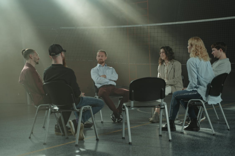 Six adults seated in a circle during a therapy session