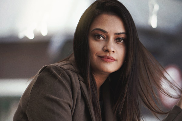 A confident smiling woman standing indoors