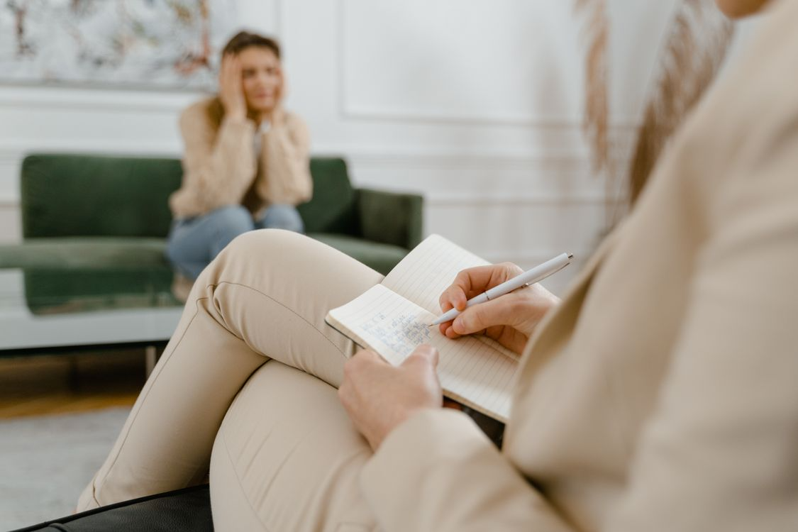 A therapist writing notes during an individual counseling session with a patient