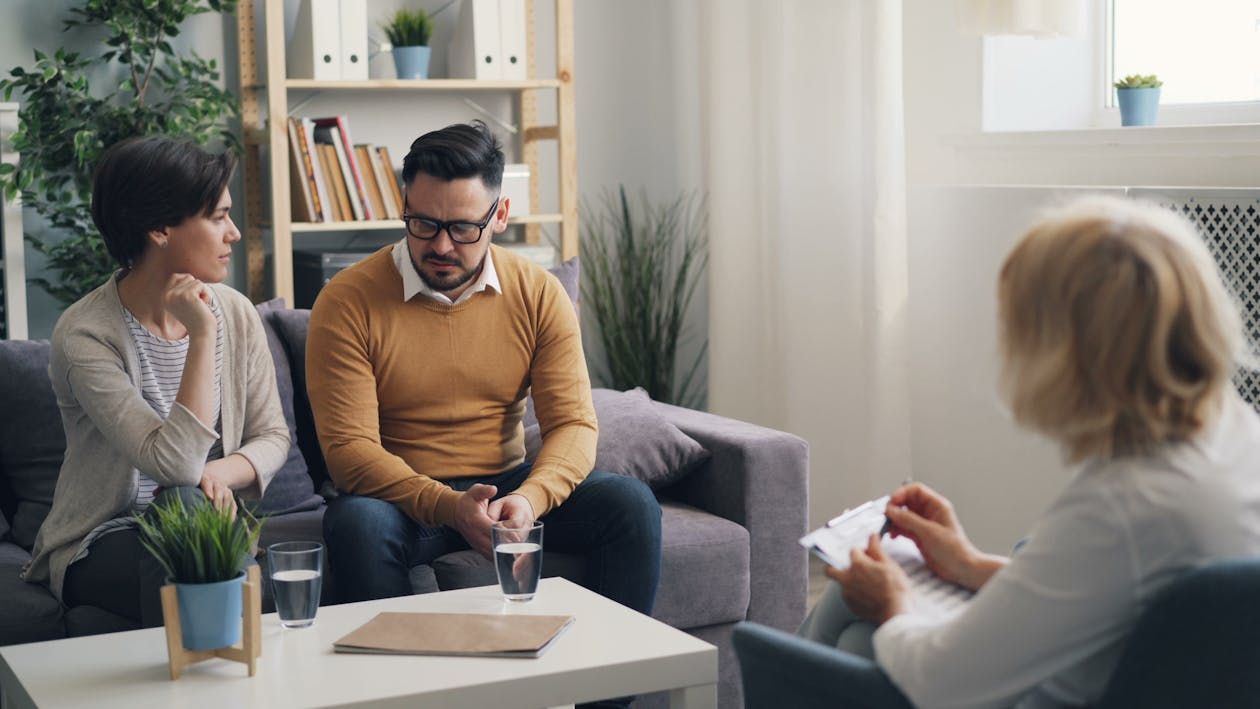 Family providing emotional support during addiction recovery therapy session with counselor