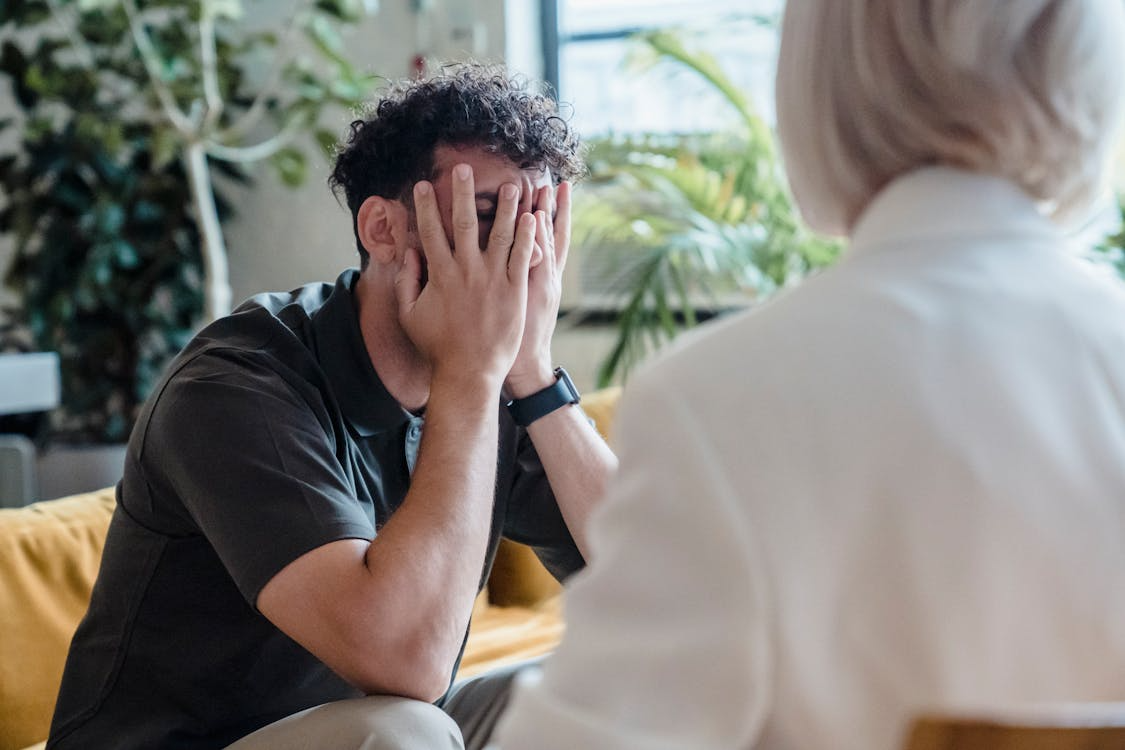 A man is hiding his face during counseling
