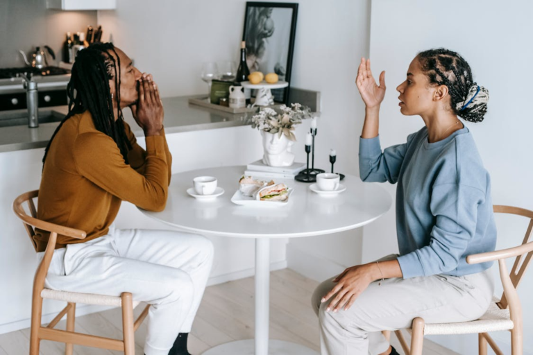 A couple is having a conversation in a kitchen setting