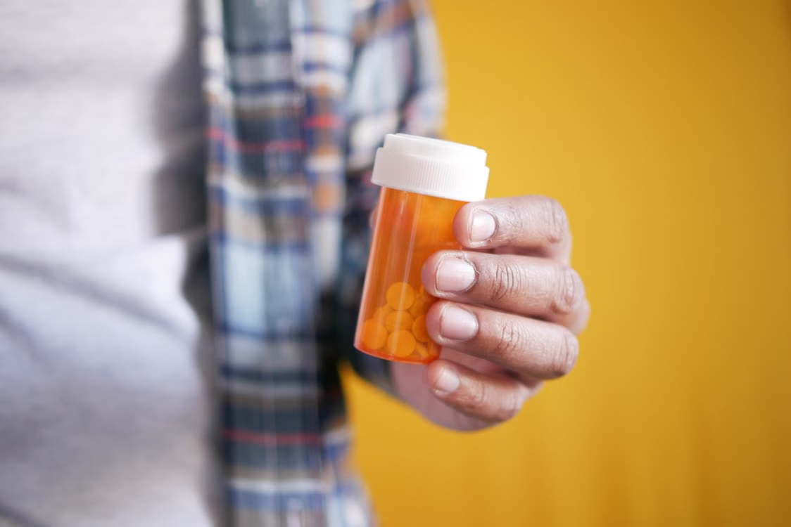 a person holding a lot of pills in their hand
