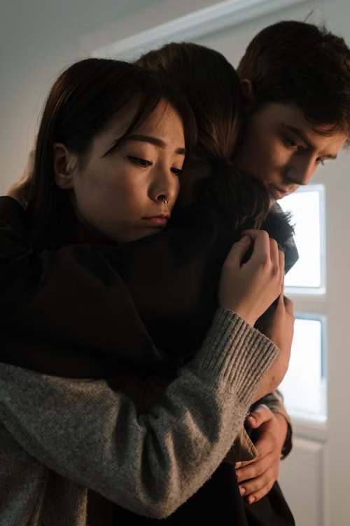 family members hugging each other in support
