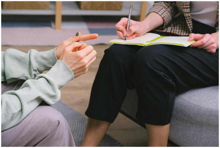 Close-up of a counselor taking notes in a notebook
