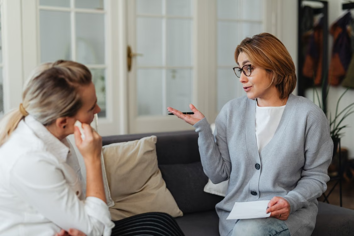 Counselor speaking with hand gestures to a woman